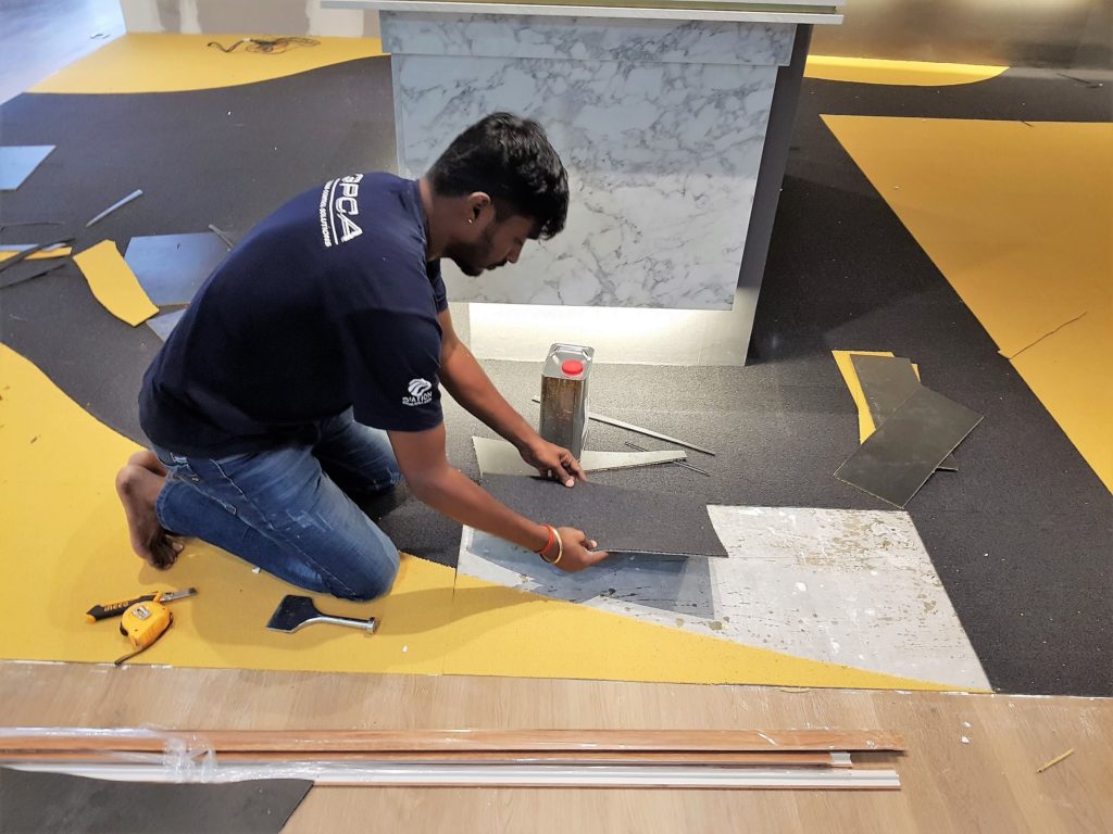Carpet Tiles are overlaid, marked and cut to the design.