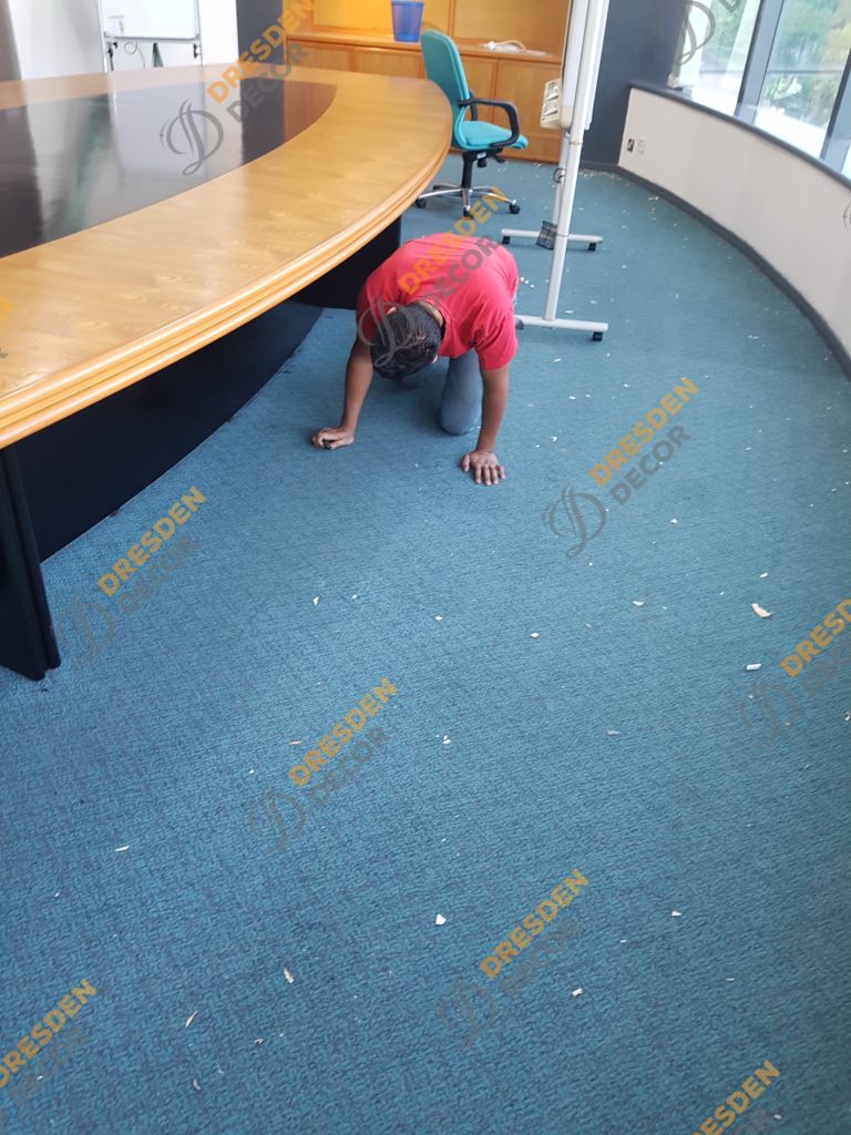 Existing carpet roll removal in progress.