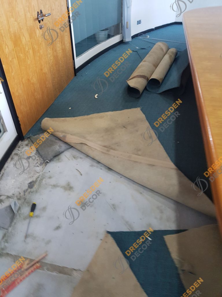 Existing carpet roll removal in progress.